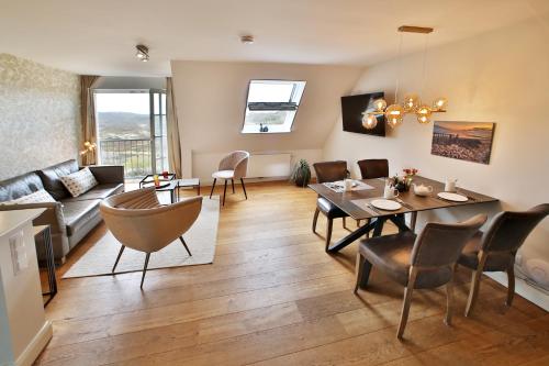 a living room with a table and a dining room at ApartHotel Seepferdchen in Hörnum