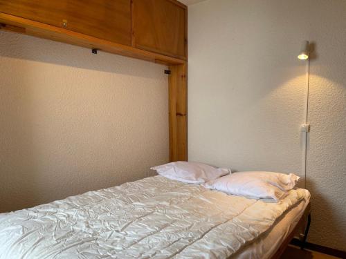 a bed with two pillows on it in a room at Appartement Samoëns, 2 pièces, 7 personnes - FR-1-624-15 in Samoëns