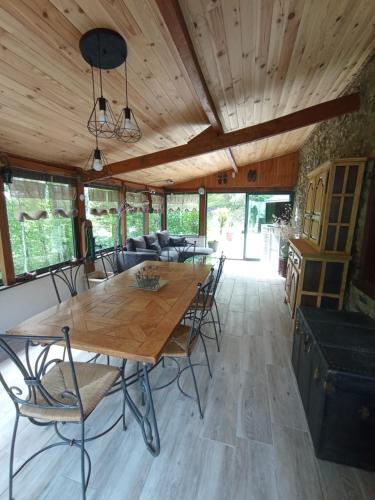 une salle à manger avec une table et des chaises en bois dans l'établissement Maison avec piscine au milieu des bois, à Illartein