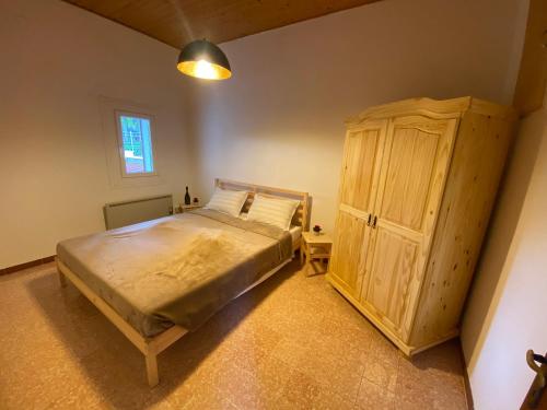 - une chambre avec un lit et une armoire en bois dans l'établissement La Villetta Marrucca, à Grosseto