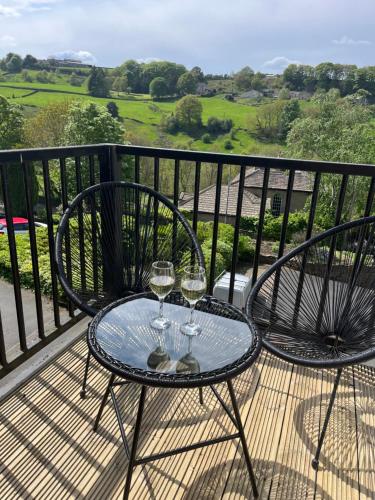 two glasses of wine sitting on a table on a balcony at 116 The Pond House in Holmfirth