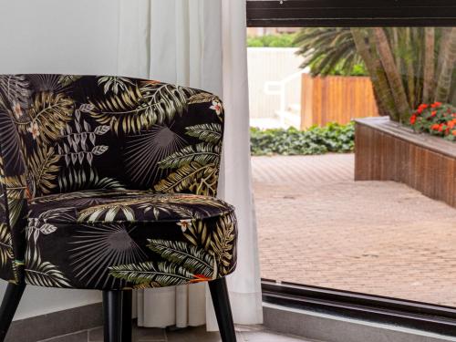a chair sitting in front of a window at Riviera by Isrotel Collection in Eilat