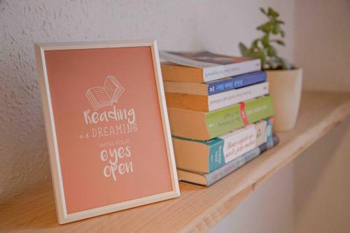 a sign sitting on a shelf next to a stack of books at Gutshof zum Wurzgarten in Hainbach