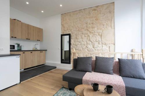 un salon avec un canapé et une cuisine dans l'établissement Appartement Broca, à Paris