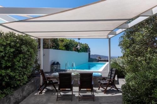 a white canopy over a patio with a swimming pool at 270 Oias View in Oia