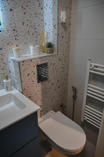 a bathroom with a white toilet and a sink at Studio apartman NEI in Tuzla