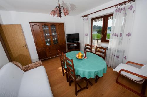 ein Esszimmer mit einem grünen Tisch und Stühlen in der Unterkunft Apartments Val Mari - Laguna in Rovinj