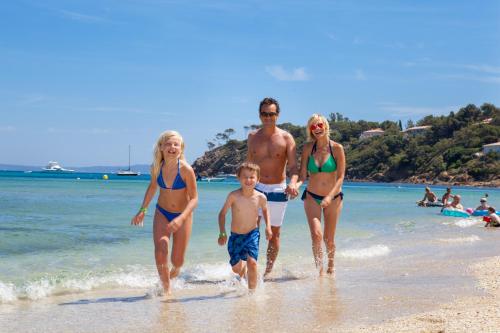 a group of people walking on the beach at Camping Le Camp Du Domaine in Bormes-les-Mimosas