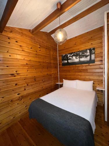 Villas Vairocana في سانتيانا ديل مار: غرفة نوم بسرير في جدار خشبي