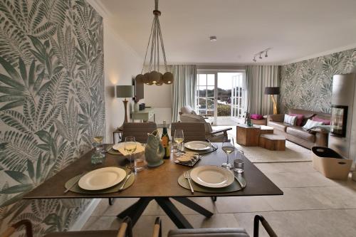 a dining room with a table and a living room at ApartHotel Seepferdchen in Hörnum