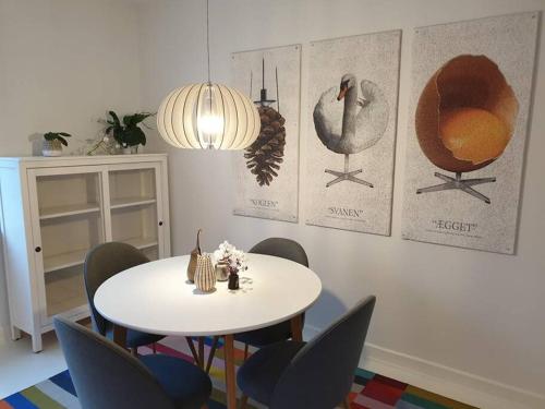 a dining room with a white table and chairs at Charmerende lejlighed i Viby in Viby