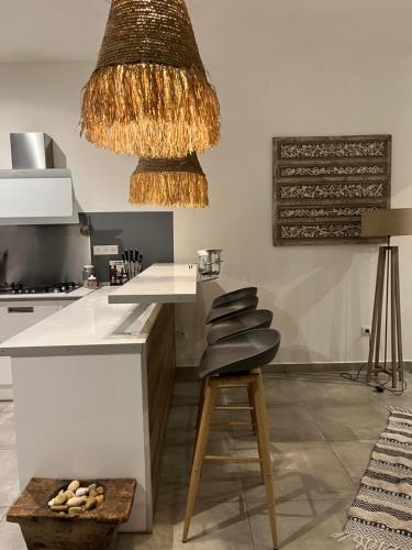 a kitchen with a white counter and a stool at Villa Ananas La Réunion et piscine chauffée in Saint-Denis