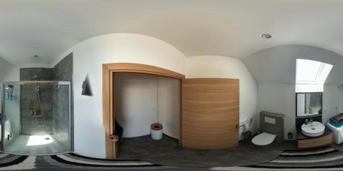 a bathroom with a shower and a wooden door at Au bout de la rue, la MER wifi accès 24 sur 24 IPTV in Sangatte