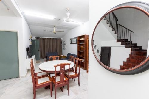 una sala da pranzo con specchio rotondo e tavolo e sedie di Twenty Seven HomeStay a Cheras