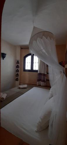 a bedroom with a large white bed with a window at Darcilla Guest House in Tarifa