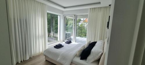Un dormitorio con una cama y una ventana grande. en Apartment Zamkowa Park, en Węgorzewo