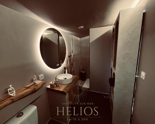 a bathroom with a sink and a mirror at Jacuzzi Vue sur Mer Helios Suite & Spa in Saint-Cyr-sur-Mer