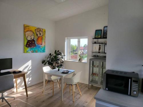 a living room with a table and a microwave at Solrig og moderne villalejlighed tæt på midtbyen 