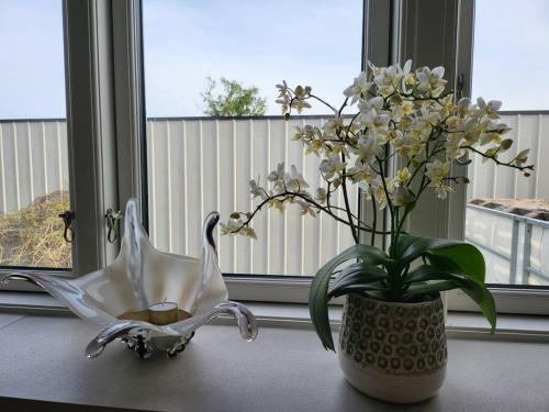 a vase of flowers and a candle on a table at Solrig og moderne villalejlighed tæt på midtbyen 