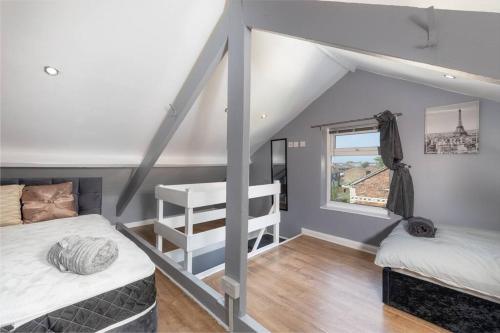 a attic room with two beds and a window at Large Parade Coastal House in Hartlepool