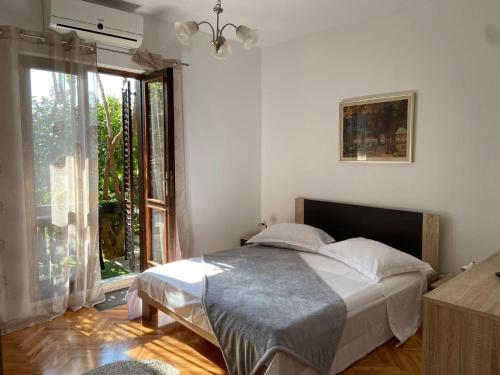 ein Schlafzimmer mit einem Bett und einem großen Fenster in der Unterkunft Guesthouse Klečak in Cavtat