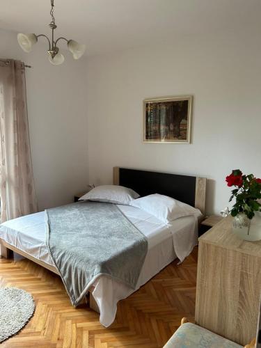 a bedroom with a bed and a plant on a table at Guesthouse Klečak in Cavtat