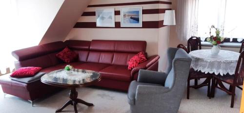 een woonkamer met een rode bank en een tafel bij Ferienhaus in der Hansestadt mit Blick auf Ostsee in Wismar
