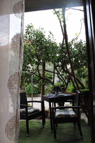 a table and chairs in a room with a tree at Guesthouse Klečak in Cavtat