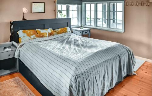 a bedroom with a large bed with a striped bedspread at Nice Home In Heggedal With Wifi And 4 Bedrooms 