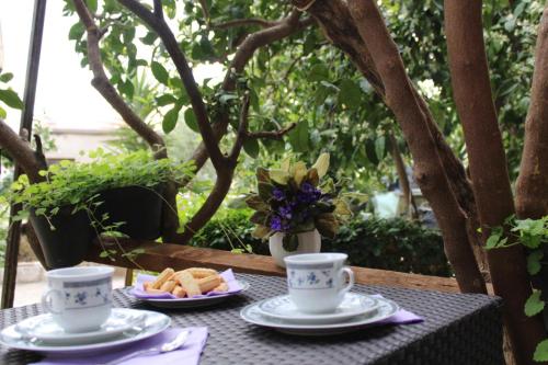 a table with two cups and plates of food on it at Guesthouse Klečak in Cavtat