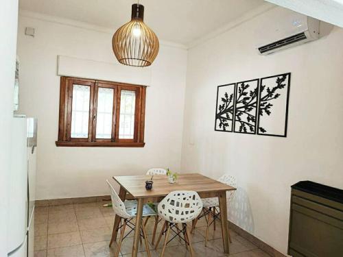 a dining room with a wooden table and chairs at Alquiler por dia Departamento 3 personas Gral Roca Casita Artigas in General Roca