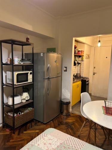 cocina con refrigerador de acero inoxidable y mesa en Departamento Impecable en Balvanera en Buenos Aires