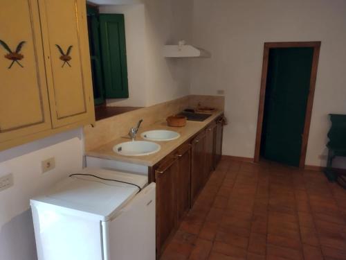 W łazience znajduje się blat z umywalką i lodówka. w obiekcie Casa nella Fortezza w mieście Pitigliano