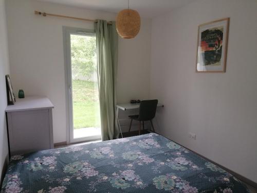 a bedroom with a bed and a desk and a window at Au fond du village in Bassy