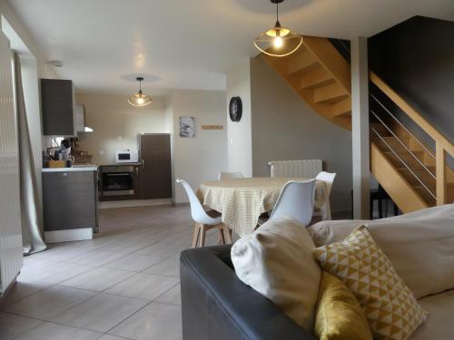 a living room with a couch and a table and a kitchen at Espace Acu-Nature in Saint-Évarzec