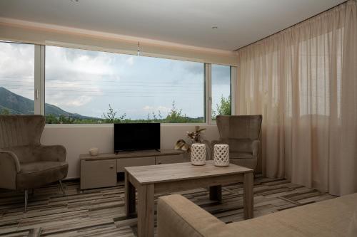 a living room with a television and a table and chairs at Casa Di Terra in Pigadhákia
