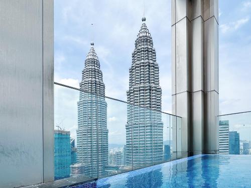 una piscina con vistas a los rascacielos Petronas en Chanel Suite KL Tower View at Tropicana The Residence, en Kuala Lumpur