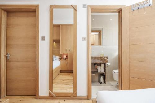 Pokój z drzwiami prowadzącymi do łazienki w obiekcie Luxe - Hyde Park - 2Bed 3Bath A/C + Lift w Londynie