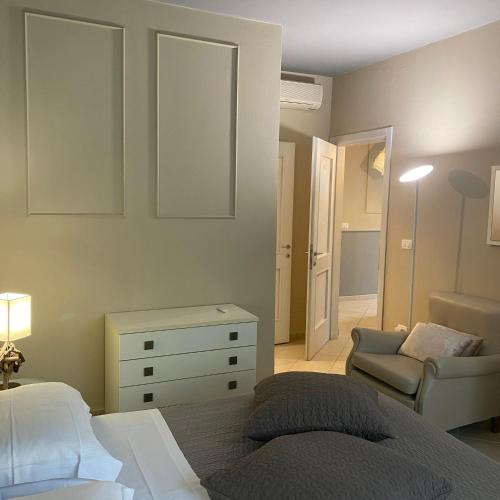 a bedroom with a bed and a chair and a dresser at Rouge Hotel International in Milano Marittima