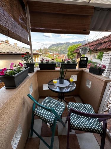 einen kleinen Tisch und Stühle auf einem Balkon mit Aussicht in der Unterkunft Lotus Apartment in Sarajevo