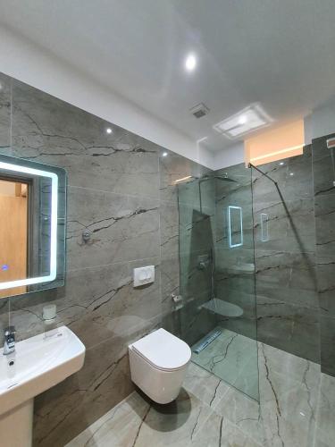 La salle de bains est pourvue d'une douche, de toilettes et d'un lavabo. dans l'établissement The Sunset View, à Saranda
