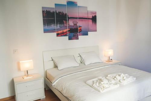 a bedroom with a white bed with two lamps at Nel centro di Locarno vicino a Piazza Grande in Locarno