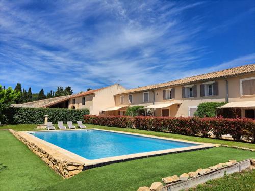 une piscine dans la cour d'une maison dans l'établissement LES DEMEURES DE LA BEAUCLAIRE, à Piolenc