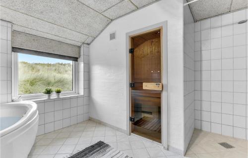 ヴィデ・サンデにあるStunning Home In Hvide Sande With 4 Bedrooms, Sauna And Wifiのバスルーム(バスタブ、窓、トイレ付)