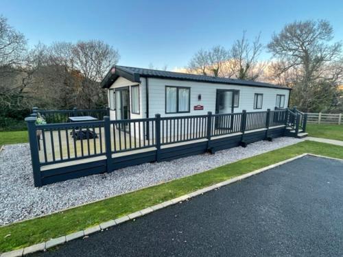 una pequeña casa blanca con valla y entrada en 3 bed luxury lodge at Hoburne Devon Bay en Goodrington