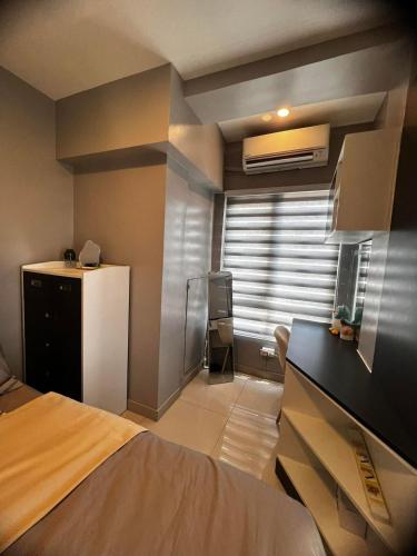 a bedroom with a bed and a window with a air conditioner at Victoria Sports Tawer in Manila