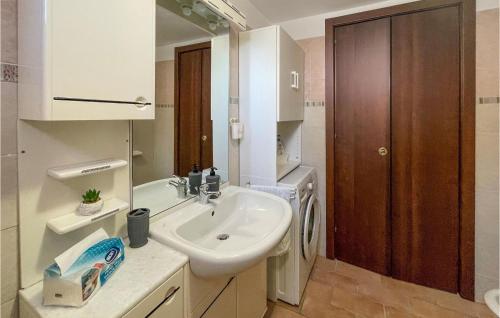 La salle de bains blanche est pourvue d'un lavabo et d'un miroir. dans l'établissement Gorgeous Home In Pisticci With Wifi, à Pisticci