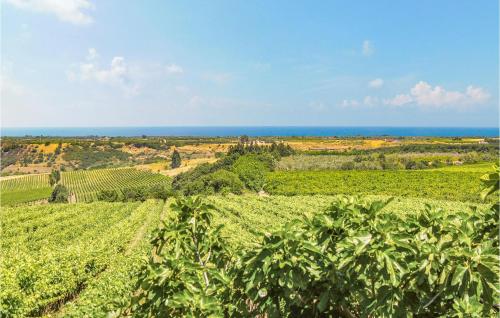 a field of crops with the ocean in the background at 2 Bedroom Gorgeous Home In Pisticci in Pisticci