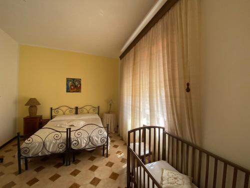 a bedroom with a bed next to a window at La "Piccola della Gioia" in Birgi Vecchi