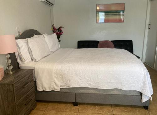 a bedroom with a large white bed with two chairs at Cozy Studio - Apt 1 - Private Entrance in Las Vegas